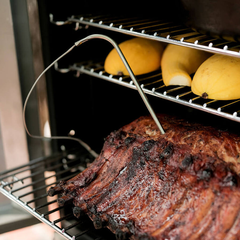 A black Masterbuilt Digital Charcoal Smoker with a glass window door, digital control panel, and wheels for mobility.