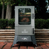 A black Masterbuilt Digital Charcoal Smoker with a glass window door, digital control panel, and wheels for mobility.